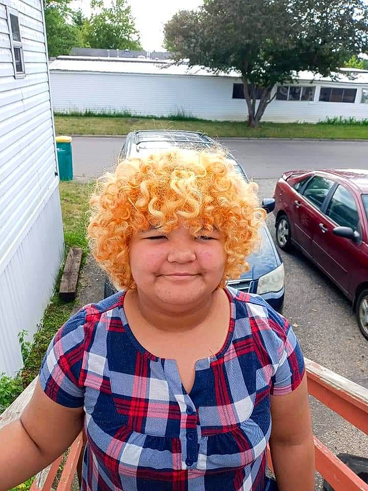 Isis is registered to the contest to win money with this photo: asphalt, blue, car, chin, eyewear, glasses, happy, headwear, joy, leisure, motor_vehicle, person, plaid, red, smile, summer, tartan, textile, tire, tree