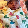 Veda is registered to the contest to win money with this photo: newborn, baby, sleeping, blanket, duck_pattern, hat, bow, striped, wrapped, infant, soft, cute, peaceful, indoors, warm_light, face, headwear, cozy, person, portrait
