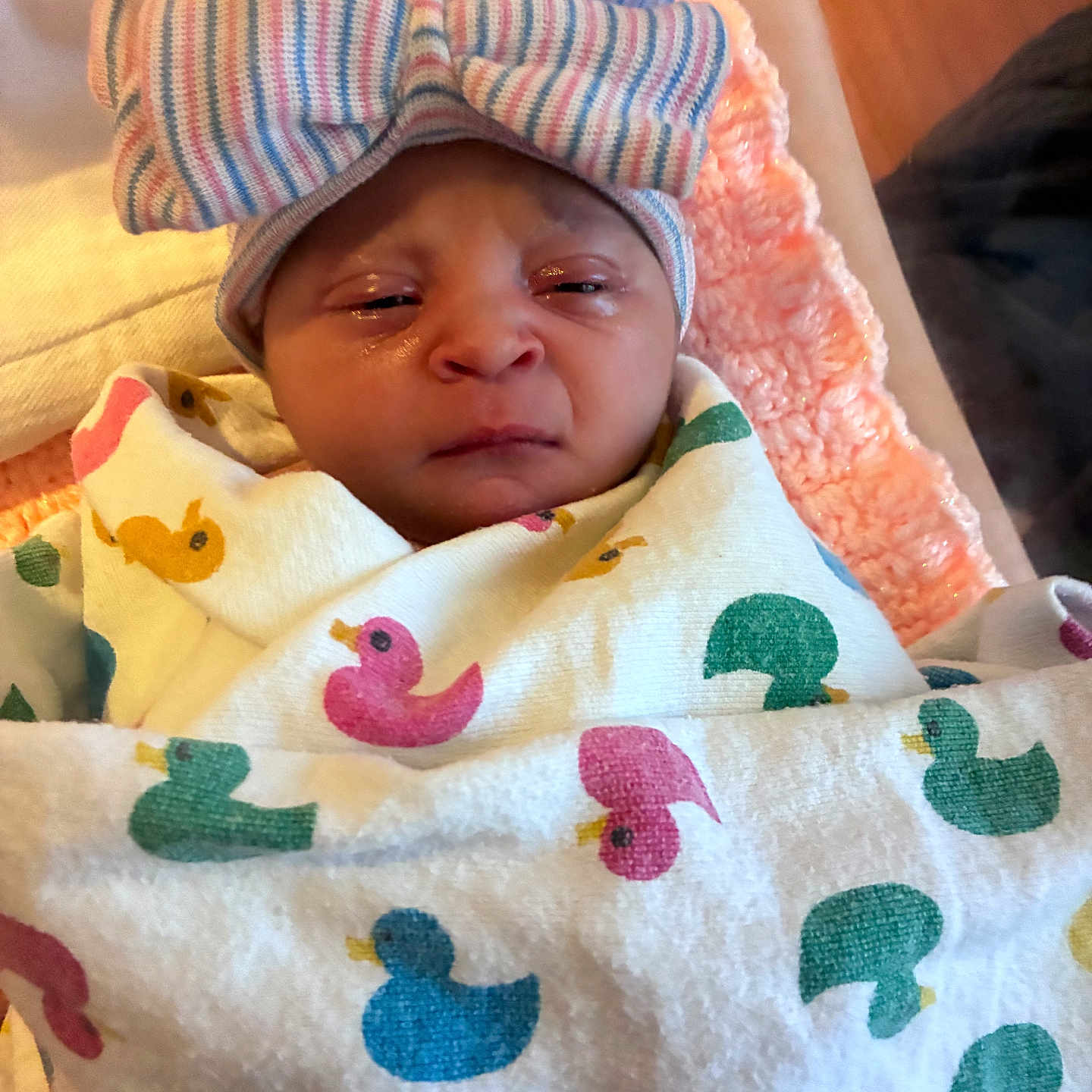 Veda joined the competition — help win amazing prizes! newborn, baby, blanket, duck_pattern, hat, bow, striped, wrapped, face, infant, cute, sleepy, indoors, soft, cozy, pink, white, colorful, fabric, portrait