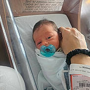 Emery joined the competition — help win amazing prizes! newborn, baby, hospital, bassinet, pacifier, blanket, hand, wristband, person, infant, bed, care, medical, patient, skin, face, wrapped, lying, tender, hospital_room