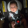 Emery is registered to the contest to win money with this photo: baby, infant, child, car_seat, harness, safety_buckle, portrait, sitting, wide_eyes, smiling, floral_clothing, indoors, vehicle, transportation, parenting, safety, headrest, warning_label, close_up, photography
