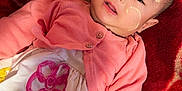 Sara joined the competition — help win amazing prizes! baby, infant, face_paint, blanket, red, pink, cardigan, dress, flower_embroidery, plush, soft, cute, child, lying_down, indoors, portrait, skin, hand, head, smile