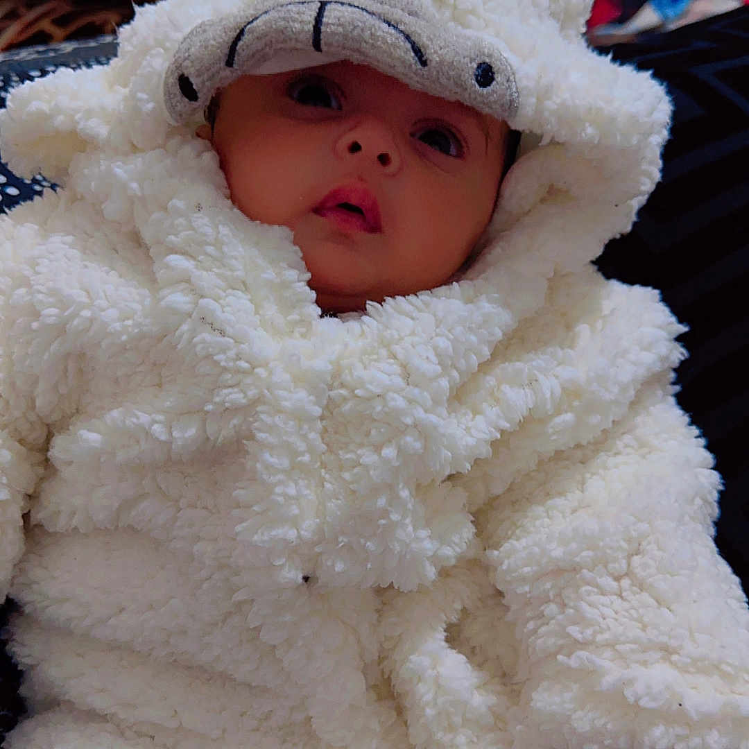 Hazel is registered to the contest to win money with this photo: baby, blanket, bonnet, cap, clothing, couch, doll, face, furniture, hat, head, hood, hoodie, knitwear, newborn, person, photography, sweater, sweatshirt, toy