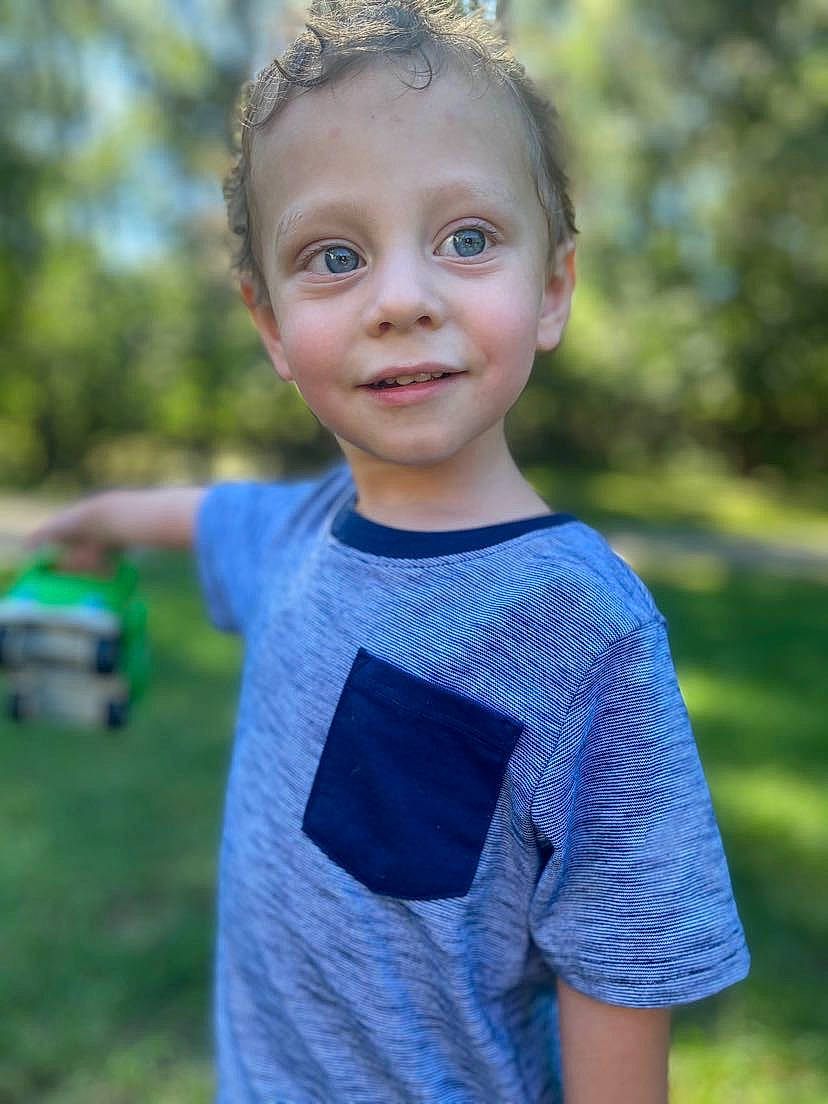 Jericho is registered to the contest to win money with this photo: azure, baby_toddler_clothing, blond, child, electric_blue, eye, face, flash_photography, grass, hair, happy, head, joy, leisure, pattern, person, sleeve, smile, spring, t_shirt