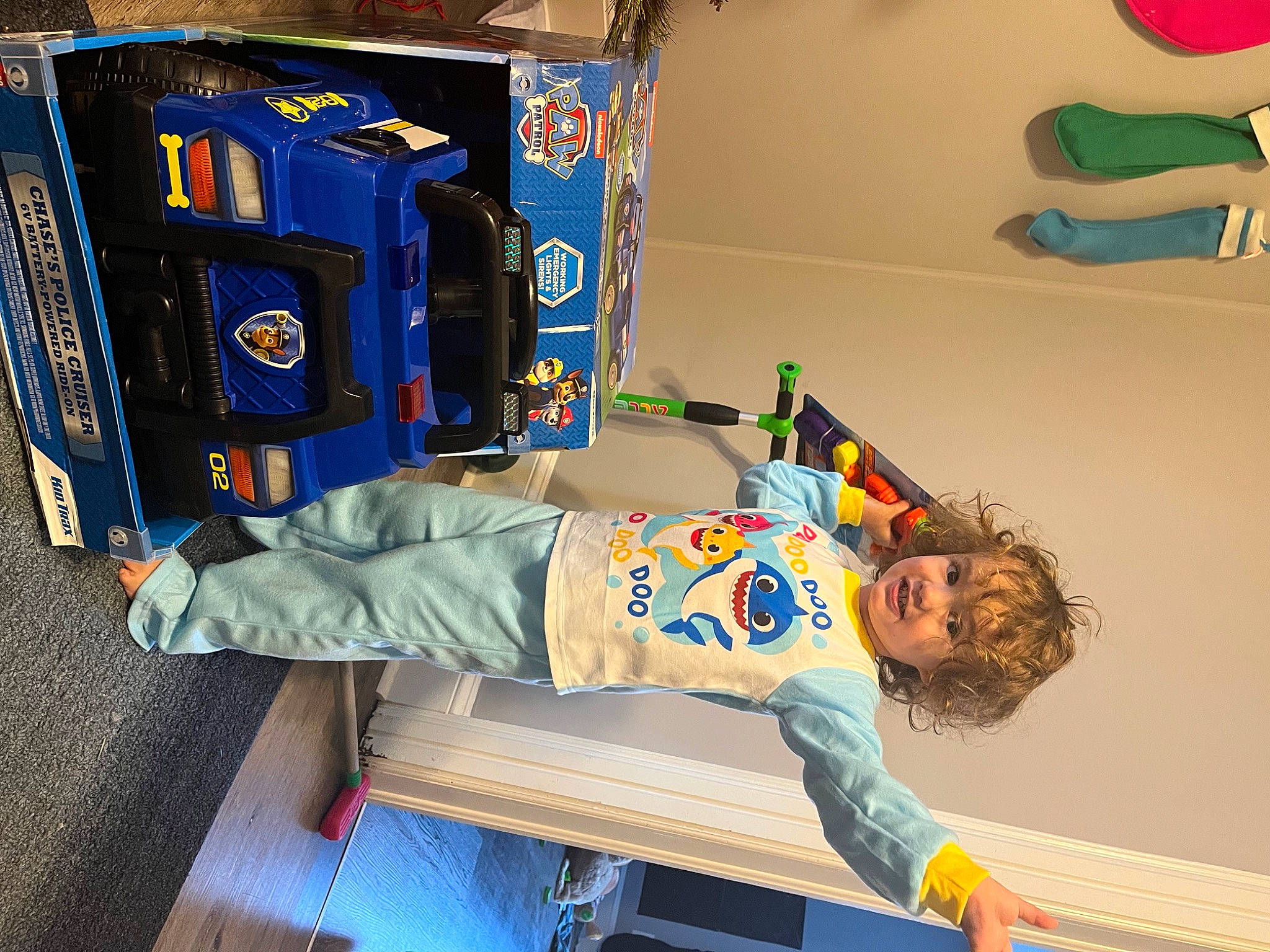 Isaac is registered to the contest to win money with this photo: automotive_exterior, automotive_tire, blue, bumper, child, electric_blue, fictional_character, fun, gas, machine, motor_vehicle, person, play, room, smile, t_shirt, tire, toddler, toy, wheel