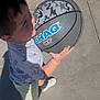 Josiah is registered to the contest to win money with this photo: activity, basketball, casual_clothing, child, concrete, daylight, holding, outdoor, person, play, recreation, shadow, shirt, shorts, sports, summer, sunlight, toy, white_shoes, young_child