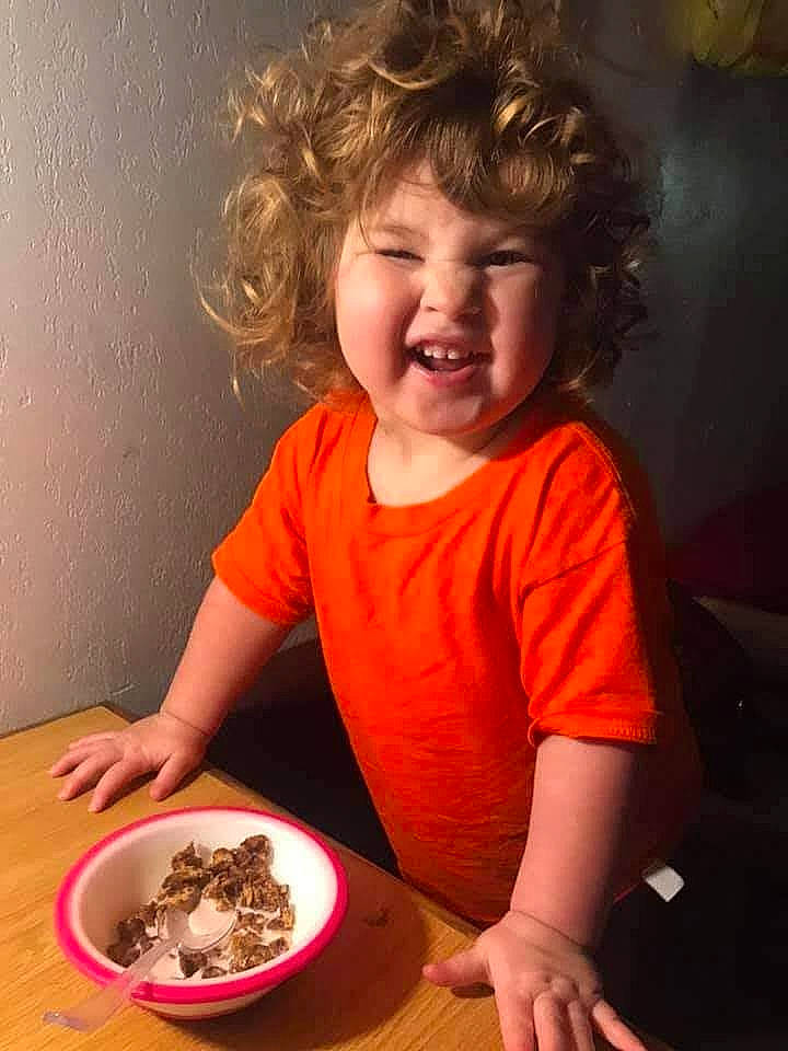 Jupiter is registered to the contest to win money with this photo: baby_toddler_clothing, chair, child, comfort_food, cuisine, dessert, dish, dishware, food, food_craving, fun, hairstyle, happy, joy, person, plate, recipe, smile, t_shirt, table