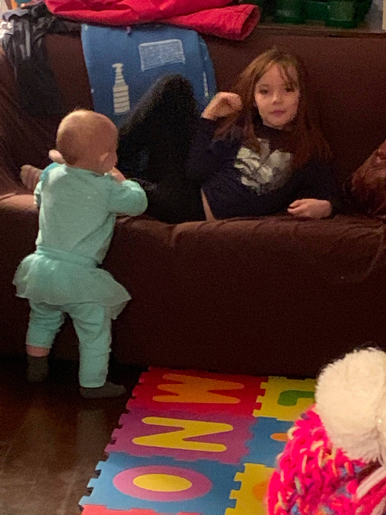 Ella-mae is registered to the contest to win money with this photo: child, comfort, couch, event, floor, flooring, fun, hardwood, interaction, lap, leisure, living_room, mammal, people, person, pink, red, sofa_bed, thigh, toddler