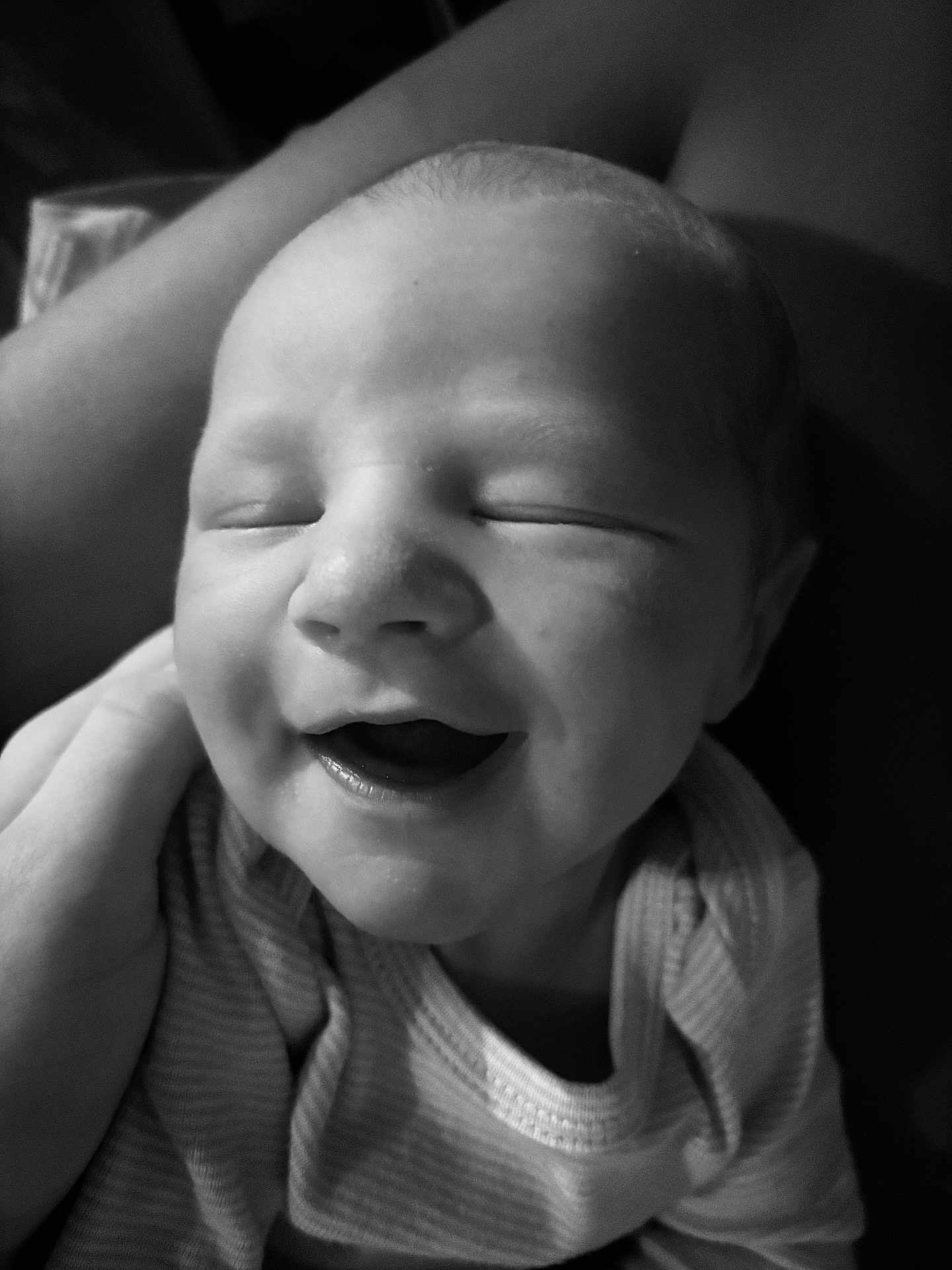 Nash is registered to the contest to win money with this photo: baby, newborn, infant, smiling, eyes_closed, mouth_open, closeup, black_and_white, monochrome, portrait, onesie, striped_clothing, hand, cheek, head, face, skin, happy, sleeping, soft_lighting
