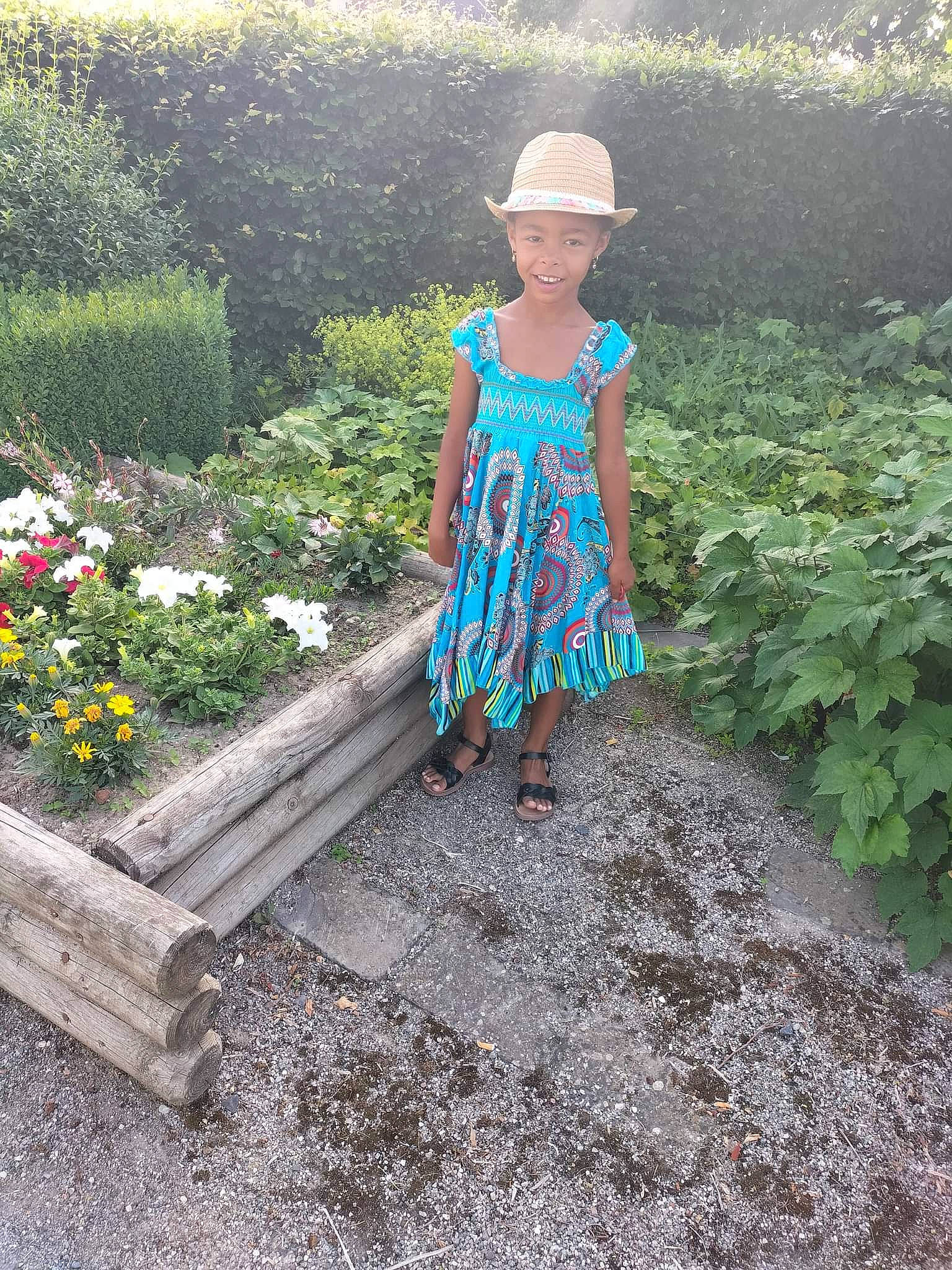 Aliyah a rejoint le concours — aidez-le/la à gagner de superbes lots ! child, day_dress, dress, electric_blue, flower, garden, grass, groundcover, hat, headwear, joy, landscape, leisure, people_in_nature, person, plant, shrub, sitting, soil, sun_hat