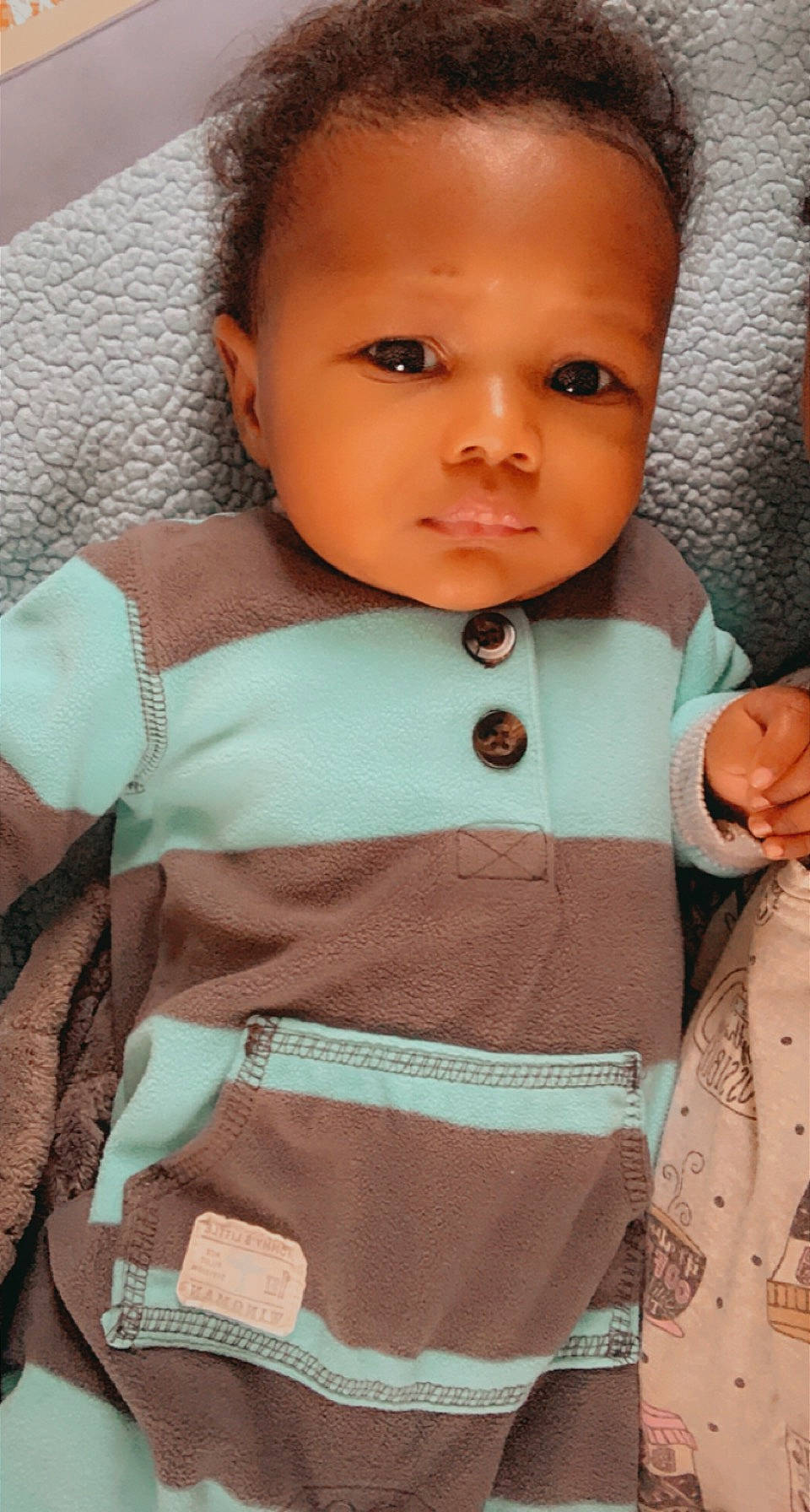 Xane is registered to the contest to win money with this photo: baby, baby_products, baby_toddler_clothing, bag, button, cheek, child, collar, ear, embellishment, eyelash, iris, lip, peach, person, pocket, skin, teal, textile, toddler