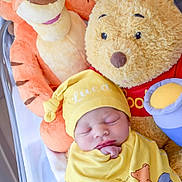 Luca joined the competition — help win amazing prizes! baby, newborn, sleeping, plush_toy, stuffed_animal, winnie_the_pooh, tigger, yellow_clothing, crib, hat, cute, child, soft_toy, indoor, infant, resting, smiling_toy, snug, cozy, portrait