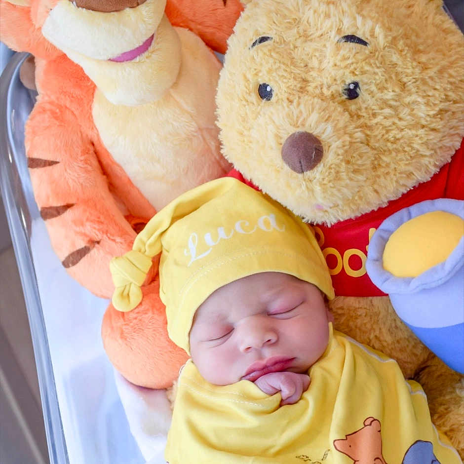 Luca joined the competition — help win amazing prizes! baby, newborn, sleeping, plush_toy, stuffed_animal, winnie_the_pooh, tigger, yellow_clothing, crib, hat, cute, child, soft_toy, indoor, infant, resting, smiling_toy, snug, cozy, portrait