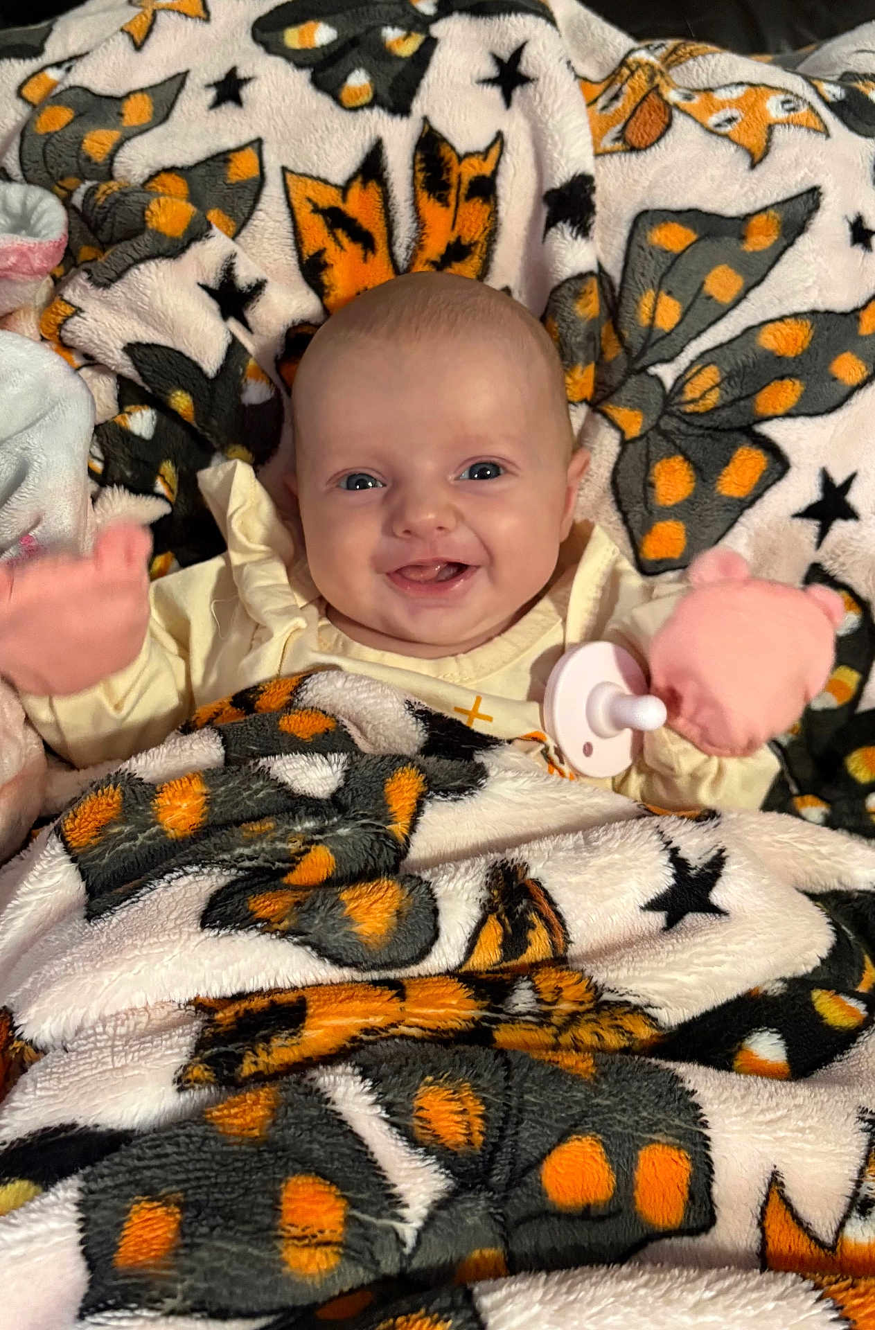 Haylee joined the competition — help win amazing prizes! baby, blanket, butterfly_pattern, mittens, pacifier, smiling, infant, cozy, cute, child, face, happy, soft_texture, warm, indoor, portrait, wrapped, lying_down, colorful, playful