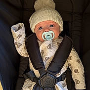 Reggie is registered to the contest to win money with this photo: baby, infant, car_seat, pacifier, hat, knit_hat, pom_pom, onesie, bear_pattern, child, cute, wide_eyes, straps, safety_harness, indoor, soft_lighting, portrait, person, warm_clothing, seated