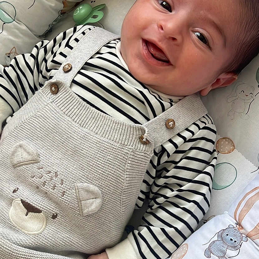 Noah a rejoint le concours — aidez-le/la à gagner de superbes lots ! baby, babylaughing, bed, clothing, crib, cushion, face, furniture, happy, head, homedecor, infantbed, knitwear, newborn, pants, person, photography, portrait, smile, sweater