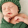 baby, blanket, child, closeup, cozy, cute, green_hat, hand, headwear, indoors, infant, knitted_hat, newborn, peaceful, portrait, resting, skin, sleeping, soft, wrapped