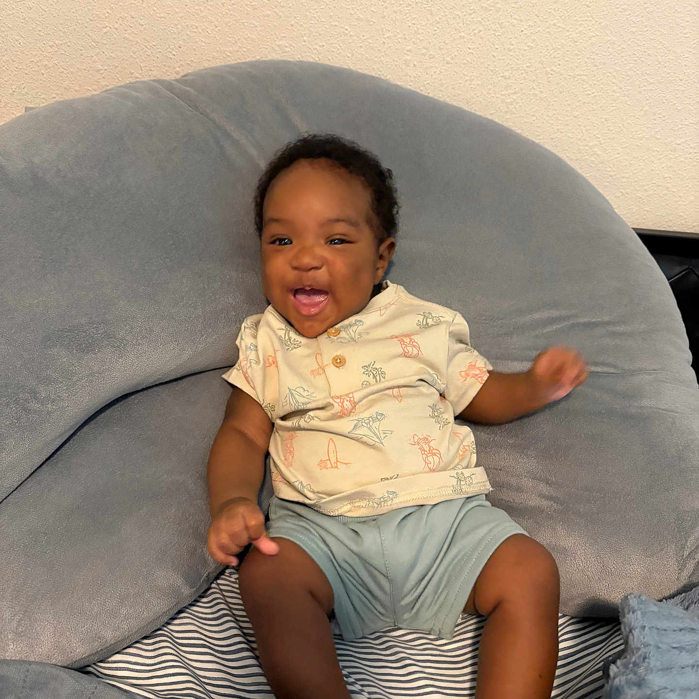 Rashad Sybren joined the competition — help win amazing prizes! baby, infant, smiling, happy, child, cushion, plush, indoor, clothing, shorts, shirt, person, seated, joyful, cute, skin, face, head, furniture, cozy