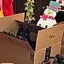 animal, black_cat, box, cardboard_box, cat, celebration, christmas, cozy, curious, cute, decorations, festive, holiday_decor, home, indoor, peeking, pet, snowman, stocking, sunflowers
