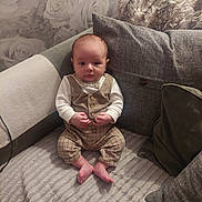 Kaylen is registered to the contest to win money with this photo: baby, infant, child, couch, pillow, vest, bow_tie, plaid_pants, hands, bare_feet, wallpaper, floral_pattern, fabric, furniture, indoor, portrait, seated, cute, curious, home