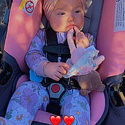 Charlotte is registered to the contest to win money with this photo: baby, child, car_seat, headband, pink, floral, onesie, toy, hand, face, sitting, seatbelt, comfort, indoor, shadow, sunlight, cute, infant, young_child, peaceful