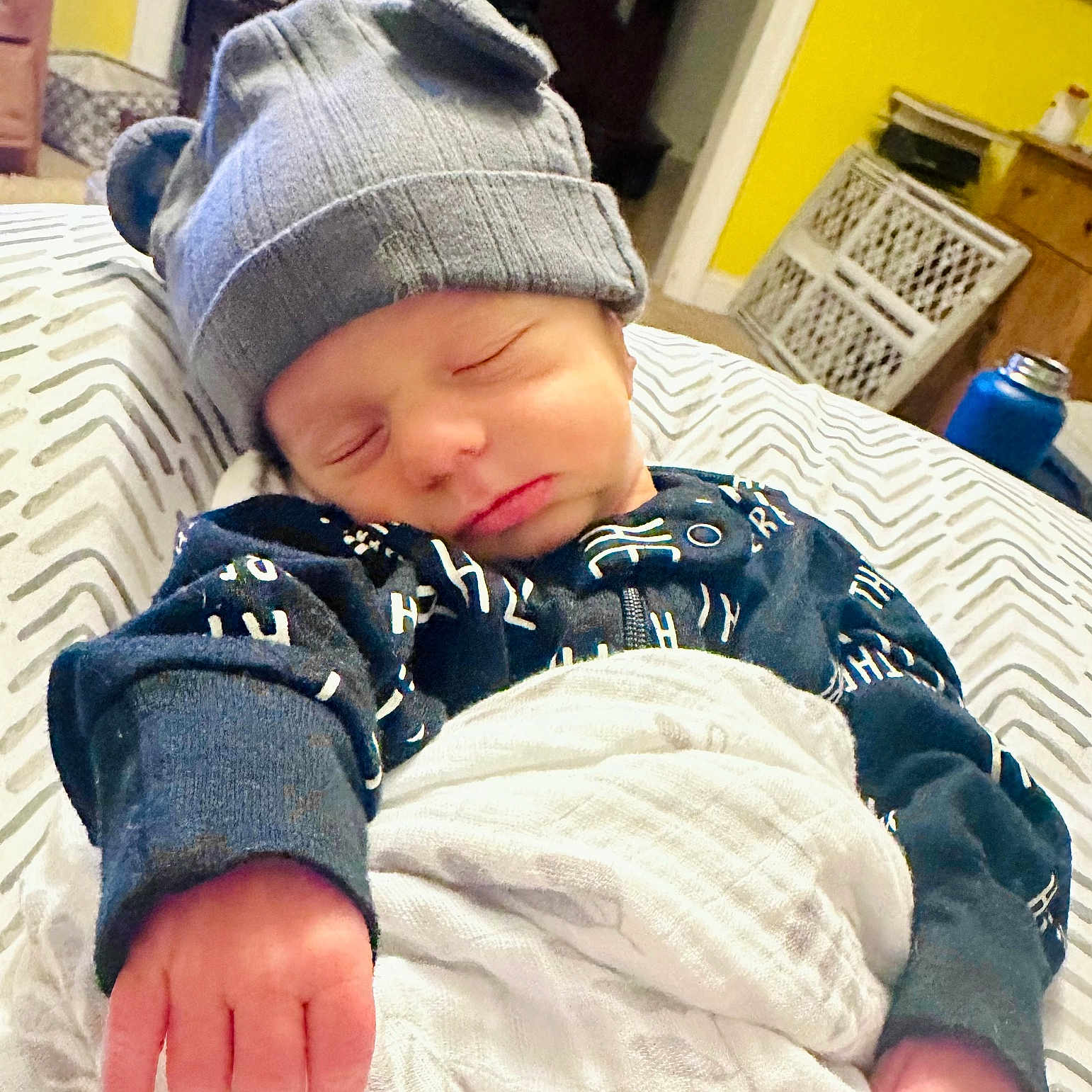 Jackson is registered to the contest to win money with this photo: baby, beanie, bed, bedroom, blanket, cap, clothing, face, furniture, glove, hat, head, indoors, newborn, pants, person, photography, portrait, room, sleeping