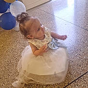 Luna participe au concours pour gagner de l'argent avec cette photo : toddler, child, dress, balloons, floor, indoor, curly_hair, white_dress, bow, party, celebration, cute, baby, person, sitting, looking_away, festive, small_child, floor_tiles, happy