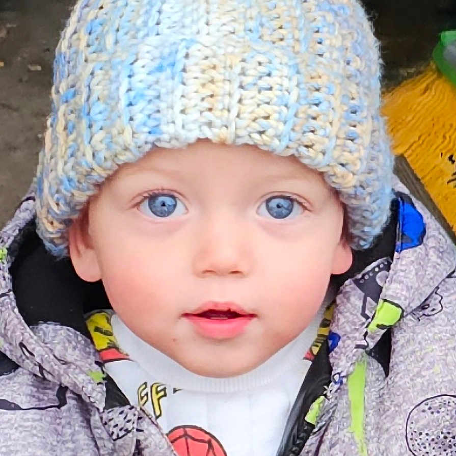 Oliver is registered to the contest to win money with this photo: baby, beanie, bonnet, cap, clothing, coat, face, glove, hat, head, hood, hoodie, jacket, knitwear, person, photography, portrait, purple, sweater, sweatshirt