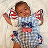 baby, infant, child, portrait, smiling, cute, clothing, blue, white, red, pattern, stars, stripes, cherry, towel, soft, lying_down, arms_up, face, expression