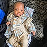 baby, beige_pants, blanket, casual, clothing, comfort, cozy, cushion, cute, face, indoor, infant, looking_at_camera, person, plaid_shirt, portrait, resting, soft_texture, striped_socks, young_child