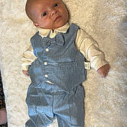 Kason is registered to the contest to win money with this photo: baby, infant, blue_suit, bow_tie, white_shirt, lying_down, blanket, soft_texture, face, cute, portrait, clothing, small_hands, small_feet, indoor, carpet, child, human, fashion, formal_wear