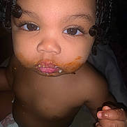 Harmonie is registered to the contest to win money with this photo: toddler, child, face, messy, food, mouth, curly_hair, eyes, skin, hand, diaper, closeup, expression, indoor, portrait, cute, baby, cheeks, skin_tone, person