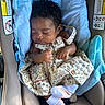 Melanii is registered to the contest to win money with this photo: baby, sleeping, car_seat, blue_blanket, floral_dress, socks, infant, child, cute, peaceful, portrait, indoors, seatbelt, resting, person, newborn, curly_hair, soft_lighting, closeup, cozy