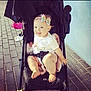 Gracie-Mae joined the competition — help win amazing prizes! baby, stroller, child, smiling, bow, headband, white_clothing, blanket, outdoor, pavement, sunlight, happy, cute, infant, seatbelt, foot, hand, person, young_child, portrait