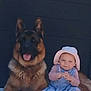 animal, baby, blue_dress, child, companion, cute, dog, floor, friendship, fur, german_shepherd, hat, outdoor, pet, portrait, resting, sitting, smiling_dog, toddler, young_child