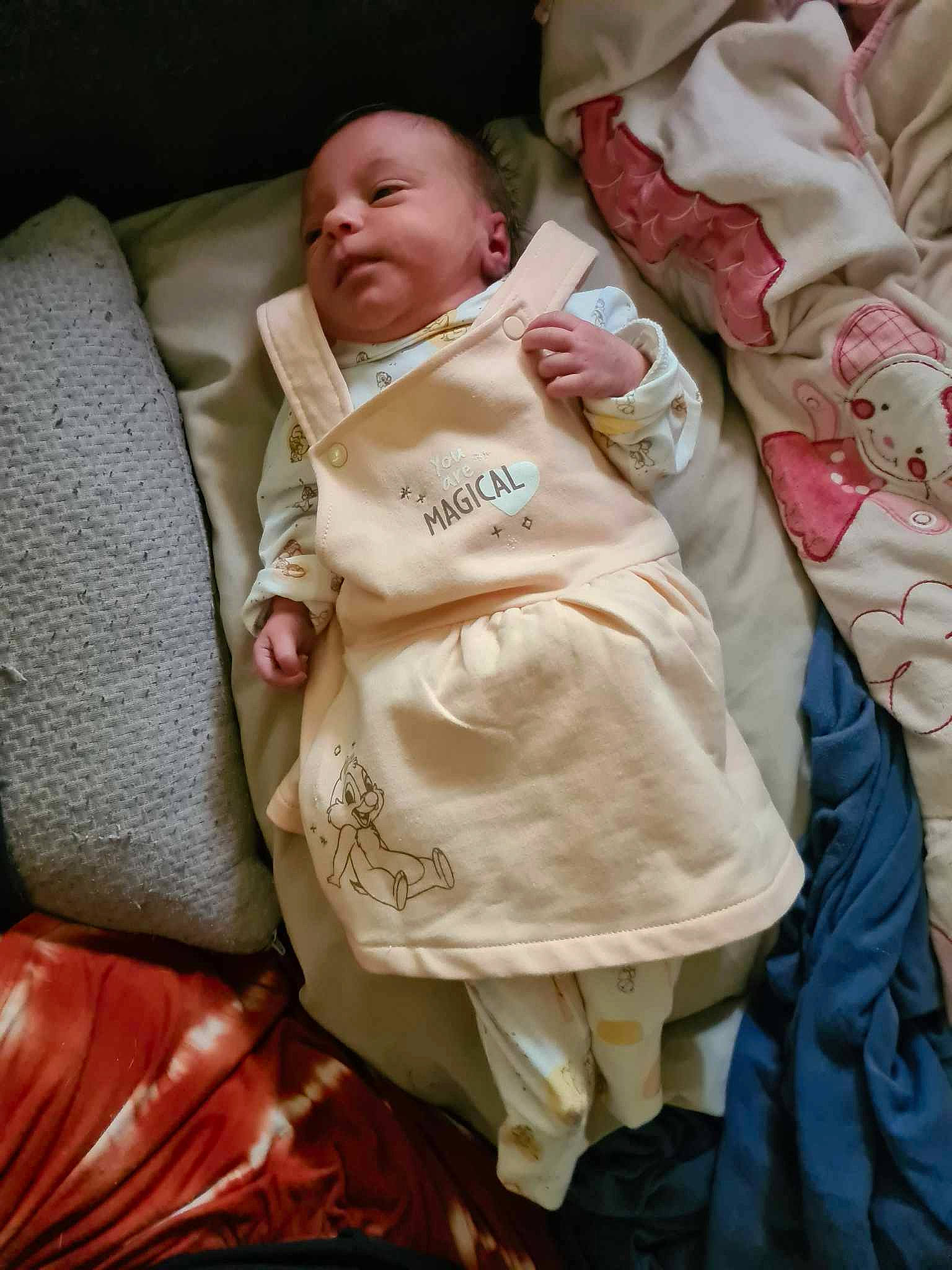 Leïlany a rejoint le concours — aidez-le/la à gagner de superbes lots ! baby, baby_carriage, baby_products, baby_safety, baby_toddler_clothing, bedding, car_seat, cheek, child, comfort, event, formal_wear, happy, head, linens, person, room, sitting, sleeve, throw_pillow