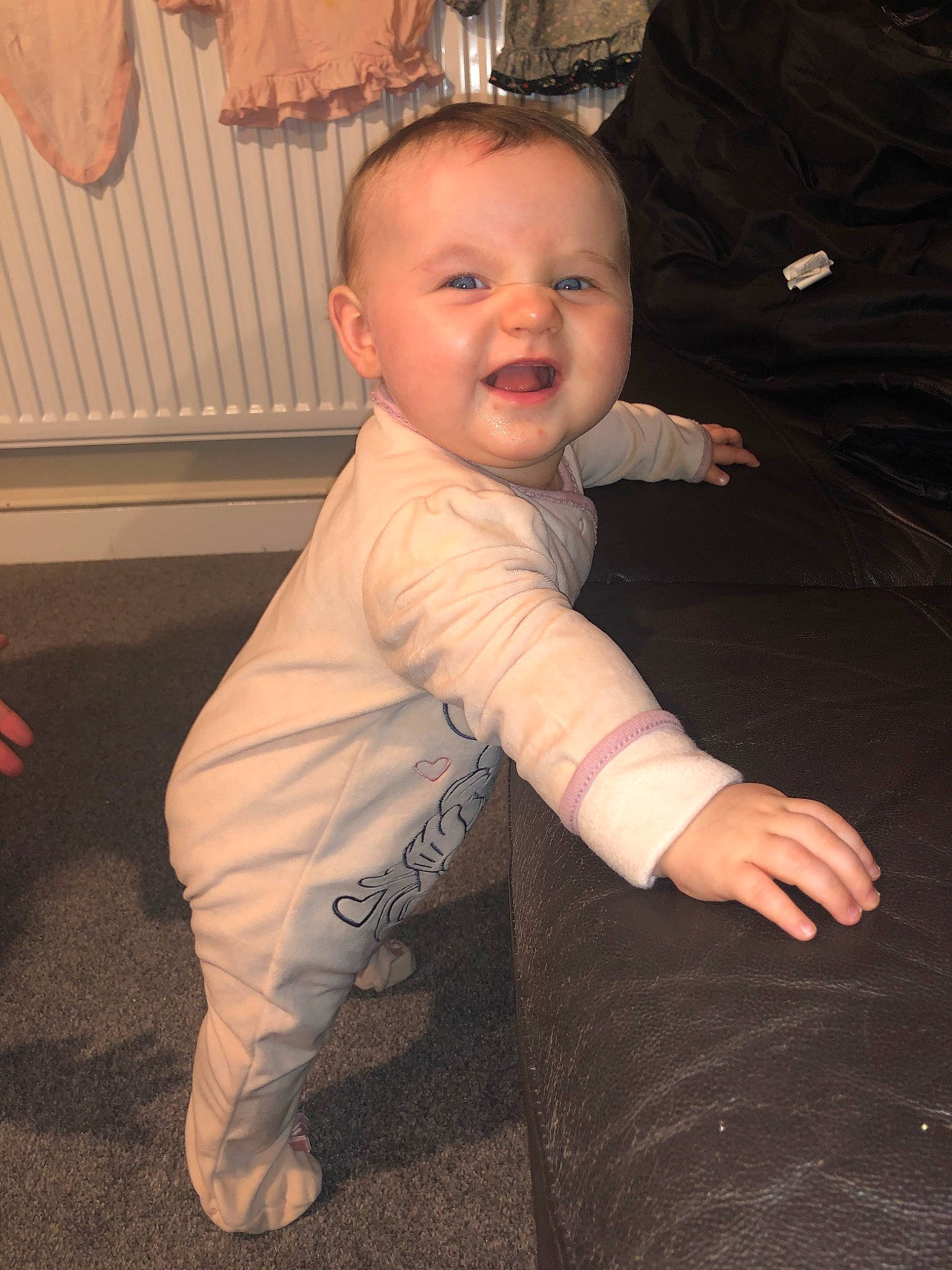 Elana is registered to the contest to win money with this photo: arm, baby, cheek, child, finger, head, leg, person, sitting, skin, smile, standing, toddler