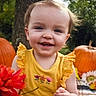 child, baby, toddler, smiling, portrait, outdoor, pumpkin, pumpkin_patch, autumn, flowers, bouquet, yellow_dress, ruffled_sleeves, garden, nature, greenery, playful, happy, close_up, seasonal