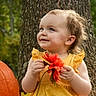 Patience is registered to the contest to win money with this photo: child, toddler, outdoor, autumn, pumpkin, flower, yellow_dress, red_flower, tree, forest, nature, portrait, smiling, happy, standing, daylight, soft_lighting, harvest, fall, family_photo