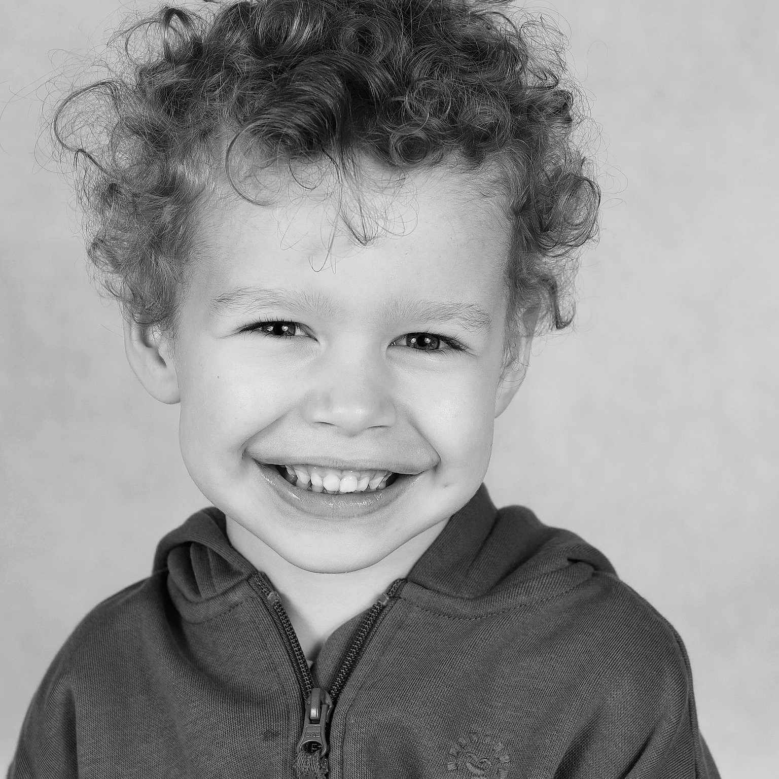 Brody joined the competition — help win amazing prizes! background, black_and_white, child, closeup, curly_hair, cute, expression, face, fashion, happy, head, hoodie, kid, light, person, portrait, smile, studio, teeth, young