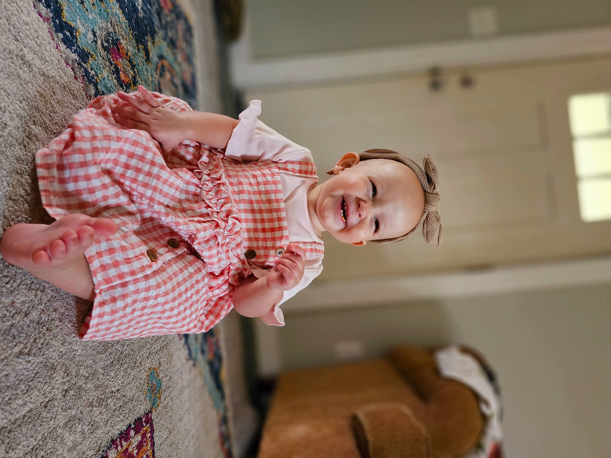 Maeve is registered to the contest to win money with this photo: arm, baby, baby_products, baby_toddler_clothing, child, comfort, couch, fun, happy, joy, laugh, linens, pattern, person, plaid, room, sitting, skin, smile, tartan