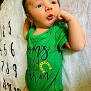 Aaron is registered to the contest to win money with this photo: baby, bed, bedroom, bodypart, clothing, couch, face, finger, furniture, hand, head, indoors, newborn, person, photography, portrait, room, shorts, t_shirt, text