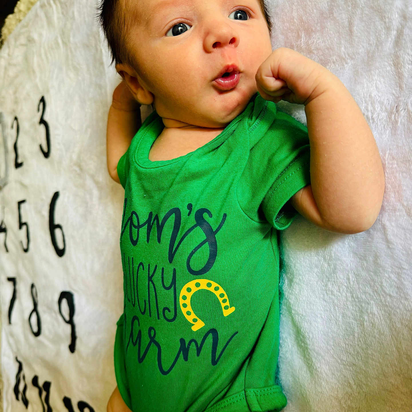 Aaron is registered to the contest to win money with this photo: baby, bed, bedroom, bodypart, clothing, couch, face, finger, furniture, hand, head, indoors, newborn, person, photography, portrait, room, shorts, t_shirt, text