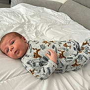 Arthur a rejoint le concours — aidez-le/la à gagner de superbes lots ! baby, infant, lying_down, bed, blanket, onesie, animal_print, tiger_pattern, white_bedspread, curious_expression, small_hand, sleepwear, indoors, soft_fabric, person, child, cute, cozy, face, head