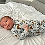 baby, infant, lying_down, bed, blanket, onesie, animal_print, tiger_pattern, white_bedspread, curious_expression, small_hand, sleepwear, indoors, soft_fabric, person, child, cute, cozy, face, head