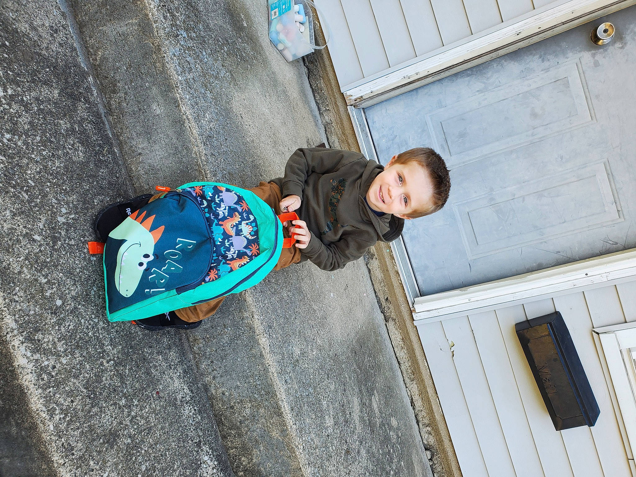 William is registered to the contest to win money with this photo: asphalt, blue, child, cobblestone, concrete, denim, electric_blue, fun, joy, leisure, pedestrian, person, recreation, road_surface, sitting, street, toddler, travel, walking_shoe, window