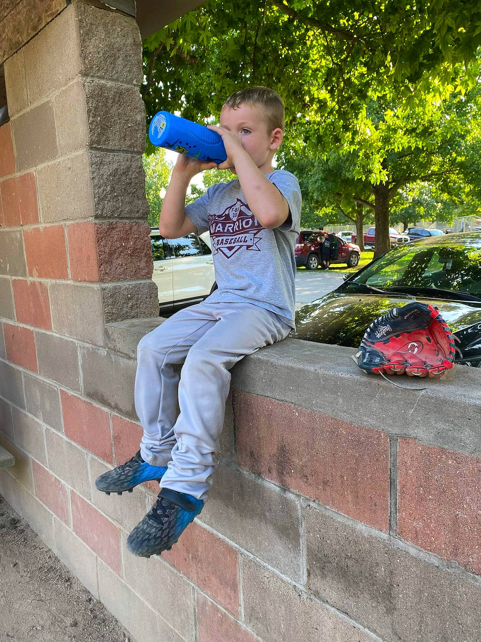 Quinton is registered to the contest to win money with this photo: brick, brickwork, cool, denim, electric_blue, eyewear, fun, grass, human_leg, knee, leg, leisure, person, plant, recreation, sidewalk, sitting, t_shirt, thigh, tree