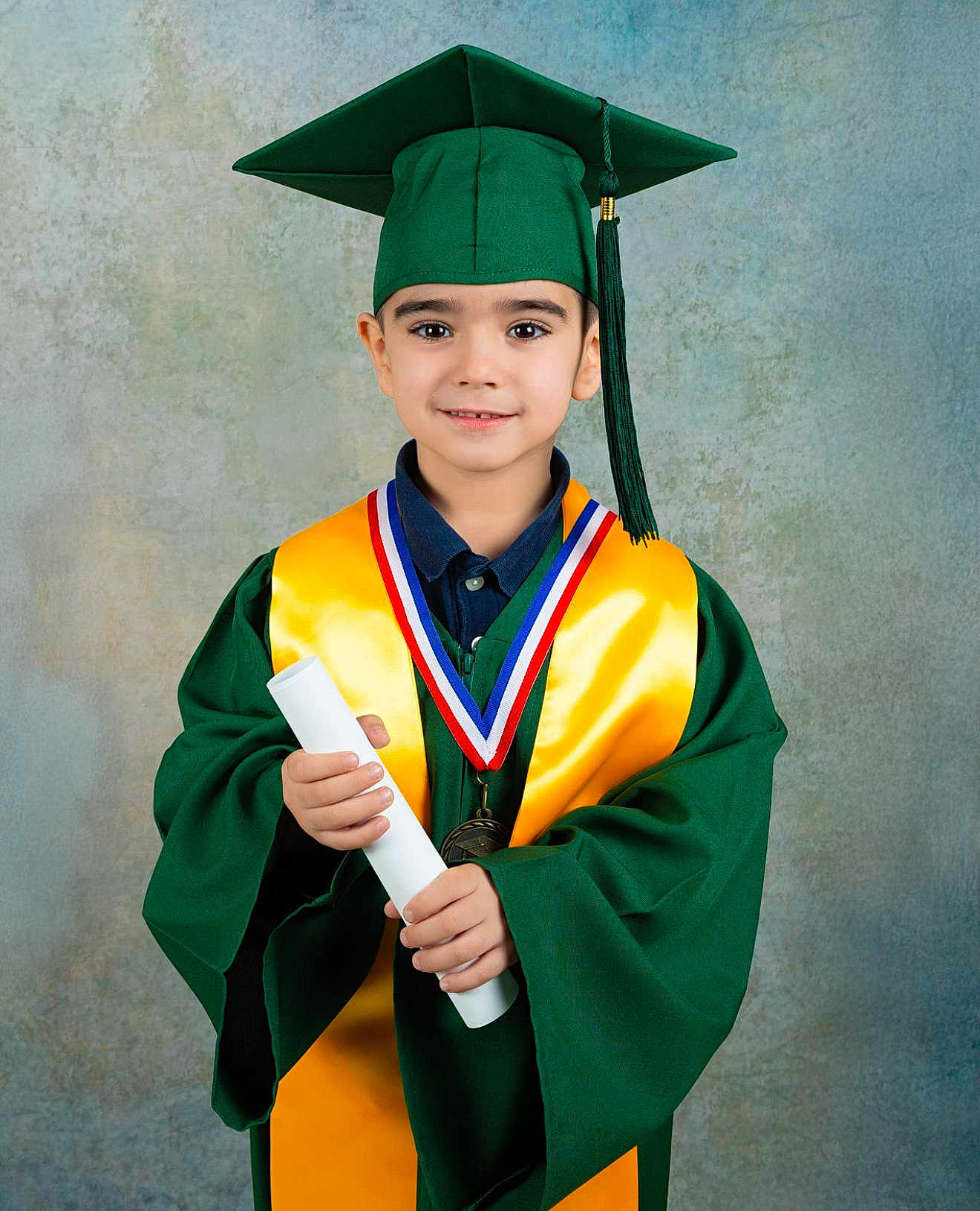 Brayant joined the competition — help win amazing prizes! child, graduate, graduation_cap, graduation_gown, medal, diploma, portrait, smile, young_boy, education, celebration, achievement, formal_wear, studio_photo, green_clothing, yellow_sash, face, person, award, indoors