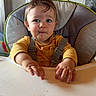 toddler, child, high_chair, yellow_shirt, expression, indoor, kitchen, baby, face, hands, seatbelt, table, food_crumbs, curious, person, furniture, home, portrait, young_child, messy