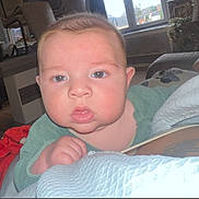 Elyo a rejoint le concours — aidez-le/la à gagner de superbes lots ! baby, infant, face, indoor, window, furniture, blue_eyes, curious, child, person, soft_surface, blanket, light, room, portrait, young, cozy, home, expression, closeup